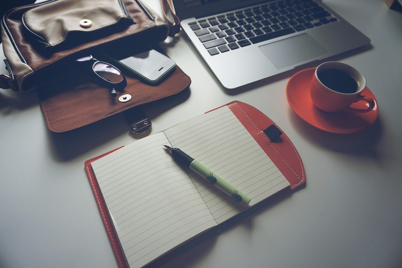 A writer in an office looks at a content brief on a second monitor while typing.